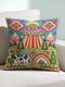 Description of a square throw pillow with a vibrant maximalist alien design. A central UFO with a large all-seeing eye hovers above a landscape with two rainbows, pink mountains, and green pine trees. A black and white spotted cow stands in the foreground. The design is a high-contrast palette of sky blue, magenta, hot pink, and meadow green. The pillow has a faux-embroidery 2D print finish on linen-feel fabric, framed by a yellow and pink scalloped floral border.
