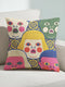 A square decorative pillow cover featuring a faux embroidery pattern of five stylized, expressive doll faces. The central face has yellow hair and pink cheeks. It is surrounded by four other faces in shades of pale beige, green, and bright pink, all with wide staring eyes and open mouths. The design uses intricate, colorful line work to create the illusion of thick woven stitching, but the fabric is a smooth print. Medallions fill the gaps.