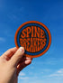 3-inch round embroidered iron-on patch made from a cotton–polyester blend; navy center with blue ring and orange outer ring; stacked orange text reads “SPINE BREAKERS”; merrowed border. Book club patch for paperback addicts, library tote flair, and literary merch collectors; makes a great gift for readers who annotate, dog-ear, and devour novels.