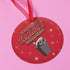 Round red metal Christmas ornament featuring angry possum in Santa hat emerging from trash can. Text reads "Have Yourself a Trashy Little Christmas" in dripping font with stars.