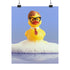 A humorous fine art print of a rubber duck modeled after Dwight Schrute, complete with glasses, mustard tie, and serious expression. Floating in soap suds, the print is framed above a retro bed with bold orange flower wallpaper and bright accent pillows.