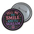 Glossy black pinback button with pastel-colored embroidered-style text that reads “Tell Me to Smile and I’ll Scream,” with lips icon and star accents.