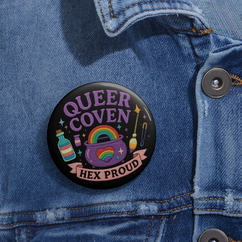Glossy black pinback button with pastel artwork of a bubbling cauldron, rainbow, potion bottles, and tools. Text reads “Queer Coven, Hex Proud.”
