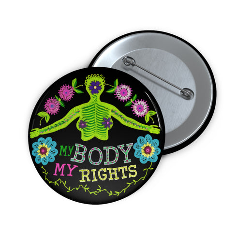 Round black pinback button featuring lime green female figure with outstretched arms and purple floral details, surrounded by pink flowers and blue blooms with multicolored "MY BODY MY RIGHTS" text. Folk art feminist pin with glossy finish and safety pin backing in 2" and 3" sizes.