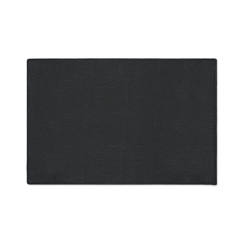 A rectangular beige doormat featuring a large, symmetrical folk art bat illustration in the center. The bat is black with coral red and mustard gold details that mimic the look of satin stitch embroidery. Surrounding the bat are stylized floral motifs in deep pink, coral, and olive green, arranged in a dense, decorative pattern. The texture visually resembles woven linen but is a smooth, flat print. The mat has a solid black trim border and is shown on a flat surface.