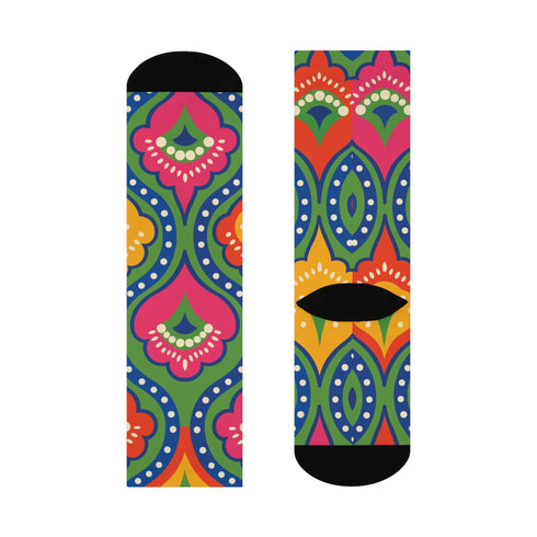 Crew-length socks featuring a vibrant 70s psychedelic pattern on a dark emerald green background. The design consists of vertical symmetrical medallions with hot pink scalloped edges, royal blue interior teardrops, and safety orange accents at the top ribbing. Fine white and light blue pointillist dots outline the major shapes. The heel and toe are solid black and reinforced. The fabric is a smooth. The pattern is maximalist and colorful, showcasing a retro aestheti.