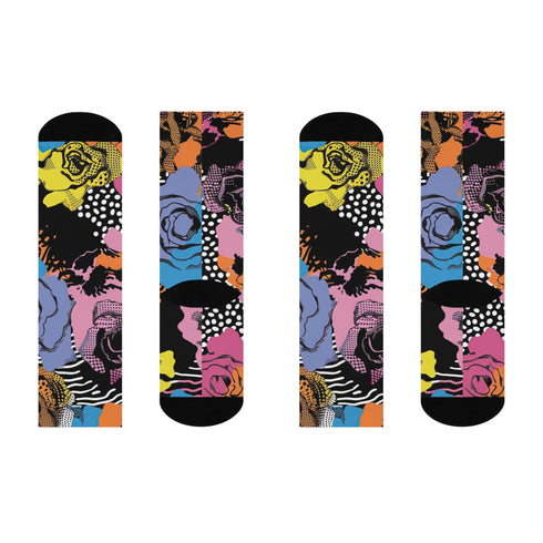 Colorful crew-length socks with a vibrant floral pop-art collage design, featuring abstract roses in yellow, lavender, pink, and orange tones, polka dots, and zebra stripes on a black background.