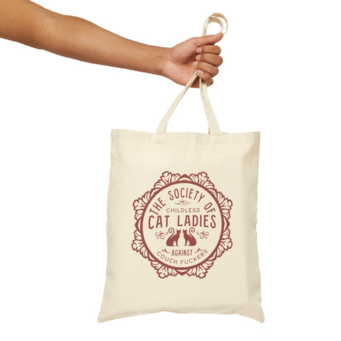 Election 2024 Canvas tote bag featuring a circular design with two cats and text "The Society of Childless Cat Ladies Against Couch Fuckers" in burgundy on a natural or black.