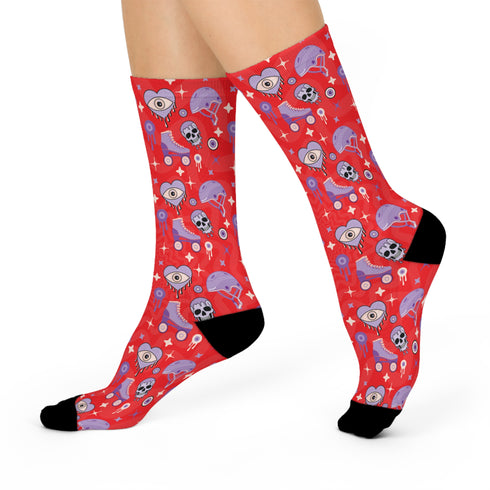 Fun and vibrant socks adorned with colorful roller skates, helmets, and wheels motifs on a red background, with black heels and toes, ideal for roller skating enthusiasts.
