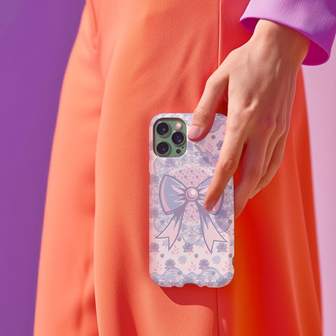 Coquette phone case featuring a pastel purple bow and pink floral lace background, dual-layer protection, UV protected, compatible with iPhone, Samsung Galaxy, and Google Pixel.
