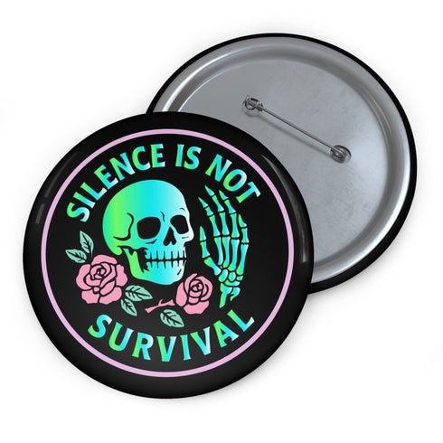 Round enamel pinback button available in 2.5″ or 3″ sizes with a black base and high-gloss finish. The design features neon green and blue gradient skull in the center, pastel pink roses and green leaves below, and mint skeleton hand on the right side. Arched text reads “SILENCE IS NOT SURVIVAL” in teal block letters. Shown styled on a denim jacket, held in hand against bright yellow backdrop, placed in a candy heart flat lay, and propped on pavement in front of graffiti wall.
