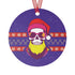 Round purple metal Christmas ornament featuring skull wearing sunglasses and Santa hat with neon yellow beard, surrounded by Nordic-style pattern bands in red and yellow.