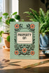 A sage green hardcover spiral planner for 2027-2028 with the title "The 2027 Planner of Controlled Chaos" in a funky, retro 70s-style font. The cover features a groovy illustration of orange and pink flowers in a vase, with one flower depicted as an eyeball. The text reads "Bloom where you're planted. Or just wilt artfully." and "Notes from the Void." The planner has a gold metal wire-o binding. The back cover shows a decorative floral frame with a "Property Of" section