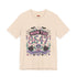 A short sleeve unisex crewneck t-shirt featuring a detailed Moon Tide 8647 graphic centered on the chest. The design includes bats, crescent moons, and spiderwebs at the top, with Moon Tide in a dripping font above a large 8647 rendered in shell patterned bubble numbers. The bottom features a skull inside a scallop shell, roses, and a Saltwater Spell banner. The color palette uses mint green, lilac, and salmon pink with black outlines. The shirt is shown in light pink, lavender, and cream.