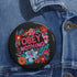 A black round pinback button featuring floral embroidery-style designs and bold red text that reads "Obey Nothing."