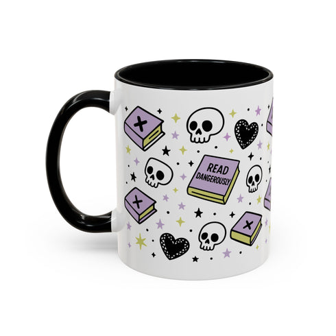 The Gothic Read Dangerously Mug Accent Coffee Mug (11, 15oz) is a BPA-free white ceramic mug with a black handle. It features books, skulls, hearts, stars, dots, and "READ DANGEROUSLY" in glossy black, purple, and yellow.