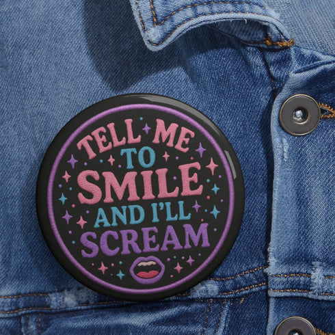 Glossy black pinback button with pastel-colored embroidered-style text that reads “Tell Me to Smile and I’ll Scream,” with lips icon and star accents.