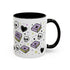 The Gothic Read Dangerously Mug (11 or 15oz) is a glossy white ceramic coffee mug with a black handle/interior, featuring pastel purple books, skulls, black hearts, stars, and “READ DANGEROUSLY!” in bold. BPA-free.