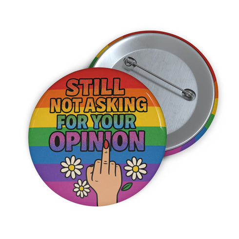 Round glossy pinback button measuring 2.25 inches with a bold rainbow pride flag background. Centered text reads “Still Not Asking For Your Opinion” in black, yellow, blue, and purple letters. Below the text is an illustrated hand with painted red nails giving the middle finger, surrounded by white daisies. The design is printed on tinplate with a scratch- and UV-resistant mylar coating. Button features a strong safety pin backing, perfect for bags, jackets, or pride outfits.