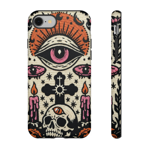 A vertical phone case design featuring a faux crochet texture illusion printed on a cream background. The symmetrical pattern centers on a large black eye with a pink iris and rust-orange sunburst lashes at the top. Below the eye is a black cross surrounded by small black stars. The bottom features a skull with a third rust-orange eye on its forehead. Flanking the skull are two candles with orange flames and rust-colored leaves. The design mimics the look of stitched yarn but is a 2d print.