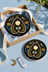 A close-up photograph of a glossy ceramic coaster featuring a Planchette occult design on a deep black background. The symmetrical graphic displays a central blue All-Seeing Eye with gold sunburst lines, topped by a white circle, and flanked by gold flowers with blue stems. At the top, the text "YES" is printed in gold on the left and "NO" on the right. Gold stars and crescent moons are scattered around the perimeter. The flat, round coaster has a highly visible high-gloss glaze.