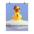 A humorous fine art print of a rubber duck modeled after Dwight Schrute, complete with glasses, mustard tie, and serious expression. Floating in soap suds, the print is framed above a retro bed with bold orange flower wallpaper and bright accent pillows.