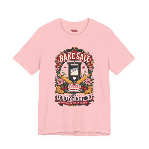 A short sleeve unisex crewneck t-shirt featuring a vintage style emblem graphic centered on the chest. The design features a red banner reading BAKE SALE above a black guillotine. Two crossed wooden rolling pins sit below the guillotine, above a layered pink and white cake with a cherry. The graphic is flanked by pink flowers, cherries, and stacks of gold coins. A bottom banner reads FOR THE GUILLOTINE FUND EST. WHENEVER THEY GOT TOO GREEDY. The shirt comes in light pink, cream, and blue.