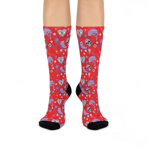 Fun and vibrant socks adorned with colorful roller skates, helmets, and wheels motifs on a red background, with black heels and toes, ideal for roller skating enthusiasts.