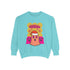 A holiday sweatshirt featuring a cute ghost character wearing a Santa hat, with two smaller ghosts on either side. Above them is the playful text "Boo Humbug," surrounded by snowflakes and festive elements. The design humorously combines spooky and festive themes for a unique holiday look.