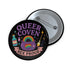 Glossy black pinback button with pastel artwork of a bubbling cauldron, rainbow, potion bottles, and tools. Text reads “Queer Coven, Hex Proud.” Styled with tarot cards, corsets, candles, and a hand holding the pin against a pink graffiti wall.