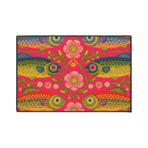 Rectangular indoor outdoor doormat featuring a vibrant hot pink background with a symmetrical maximalist pattern. The design showcases stylized sardines in yellow, lime green, and cobalt blue swimming horizontally towards a central vertical axis of blooming pale pink flowers and green vines. The imagery mimics the texture of vintage needlepoint embroidery but is a flat print on polyester. The mat is framed by a sleek black trim and features a non-slip rubber backing for safety.