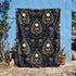 A rectangular velveteen minky blanket featuring a repeating dark academia pattern on a deep black background. The design includes gold and cream Ouija planchettes, each containing a blue all-seeing eye, a cream circle, and a light blue crescent moon framed by botanical leaves. Scattered between the planchettes are gold flowers with light blue stems, additional crescent moons, and small four-point stars. The reverse side of the blanket is made of a fluffy, textured off-white sherpa fleece.