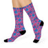 Fun and playful socks adorned with vibrant tiger head motifs on a pink background, with black heels and toes, ideal for animal lovers and those who enjoy unique designs