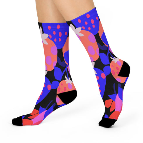 Black crew socks featuring an oversized, abstract strawberry pattern in bright pink, blue, and orange.