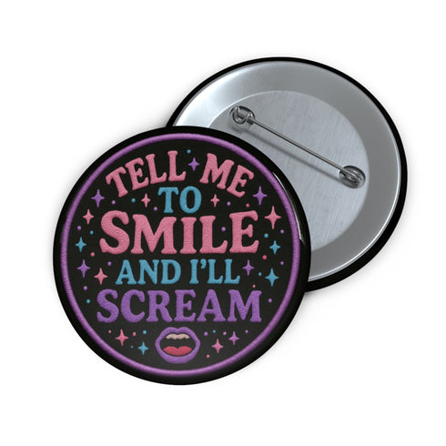 Glossy black pinback button with pastel-colored embroidered-style text that reads “Tell Me to Smile and I’ll Scream,” with lips icon and star accents.