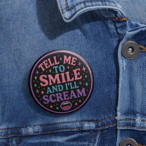 Glossy black pinback button with pastel-colored embroidered-style text that reads “Tell Me to Smile and I’ll Scream,” with lips icon and star accents.