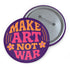 A round, glossy purple pinback button with the words "MAKE ART NOT WAR" in a groovy, retro 70s-style font. The word "MAKE" is in orange, "ART" is in a vibrant pink, and "NOT WAR" is in orange. The text is surrounded by small, stylized flower and star details. This psychedelic protest pin is a piece of activist merch with a strong metal back and safety pin clasp, perfect as an anti-war or social justice accessory for a jean jacket or backpack. The pin has a handmade, indie aesthetic.