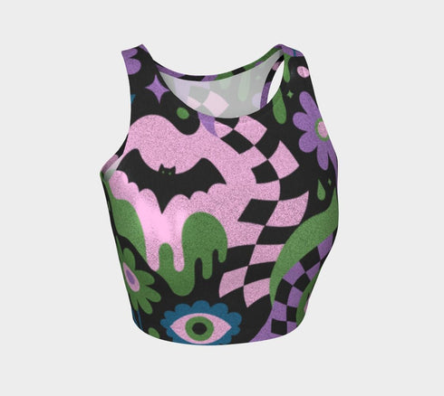 A close-up view of a sleeveless performance knit crop top featuring a vibrant pastel goth all-over print on a solid black background. The repeating pattern includes large black vampire bats flying over dripping, melted slime shapes in neon green. Wavy, warped checkerboard patterns in pastel pink, light purple, and black weave through the design. The graphic is finished with stylized, oversized pastel floral motifs and large open eyeballs staring outward.