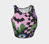 A close-up view of a sleeveless performance knit crop top featuring a vibrant pastel goth all-over print on a solid black background. The repeating pattern includes large black vampire bats flying over dripping, melted slime shapes in neon green. Wavy, warped checkerboard patterns in pastel pink, light purple, and black weave through the design. The graphic is finished with stylized, oversized pastel floral motifs and large open eyeballs staring outward.