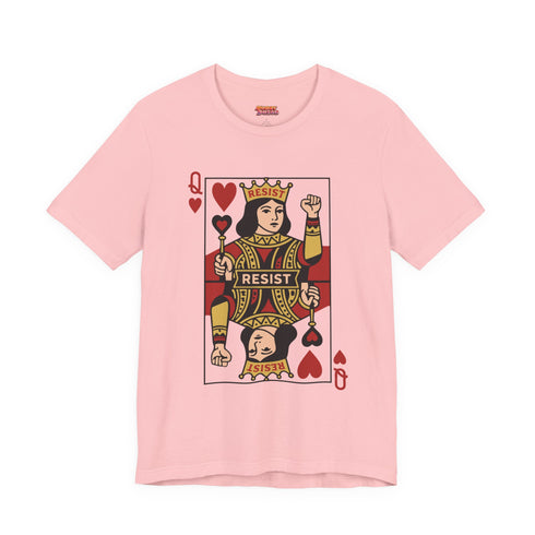 A centralized graphic design of a Queen of Hearts playing card on a cream or pink unisex t-shirt. The Queen is depicted in a maximalist folk art style, holding a heart-topped scepter and a raised fist in a gesture of solidarity. The word "RESIST" is visible on her crown and a central banner in ochre and true red tones. The layout is a centralized medallion style with rust and ochre accents and a playing card border.