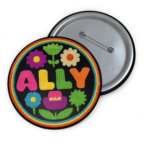 Vibrant ALLY pinback button featuring 70s-style embroidered flowers and lettering in pink, yellow, green, and blue against a black background, surrounded by a rainbow border. A colorful statement accessory combining punk activism and retro flower power aesthetics for backpacks, jackets, and protest wear.