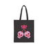 Canvas tote bag featuring pink skull cherries design. Two pink skulls connected by red stem and bow. Quirky gothic-inspired graphic on cream background. Stylish, edgy accessory for everyday use. Perfect for alternative fashion lovers.