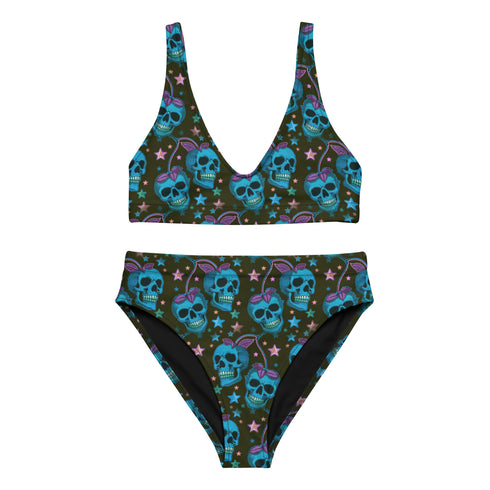 High-waisted bikini set featuring an all-over pattern of neon blue skulls with pink bows, pastel stars, and purple cherries on a dark olive green background. The top has a scoop neckline with wide straps, and the bottoms offer full coverage. A bold, punk-inspired swim look perfect for alternative fashion lovers and dopamine dressers.