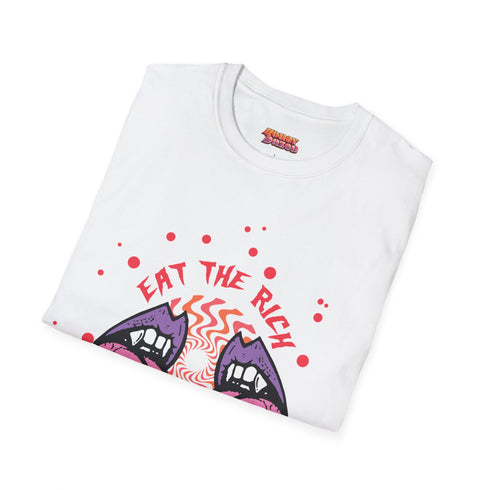White t-shirt featuring a surreal, psychedelic design centered on the chest. An open mouth with sharp vampire-like teeth and pink tongue dominates the image. Between the teeth, a hypnotic swirling pattern in rainbow colors leads to a single eyeball on the tongue. "EAT THE RICH" is written in white above the mouth. Red paint-like splatters surround the entire design, giving it a grungy, punk aesthetic. The shirt is from the "Honey Dazed" brand.