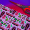 Vibrant purple wrapping paper with gothic-inspired design for 50th birthdays. Features colorful skulls wearing party hats, coffins, 'RIP 40s' tombstones, and 'Youth Dies Here' text. Perfect for edgy, humorous gifts to 50-year-olds.