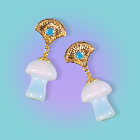 Exquisite earrings featuring ornate golden fan-shaped studs with azure stones, suspending lustrous opal mushroom charms, embodying luxurious cottagecore aesthetics.