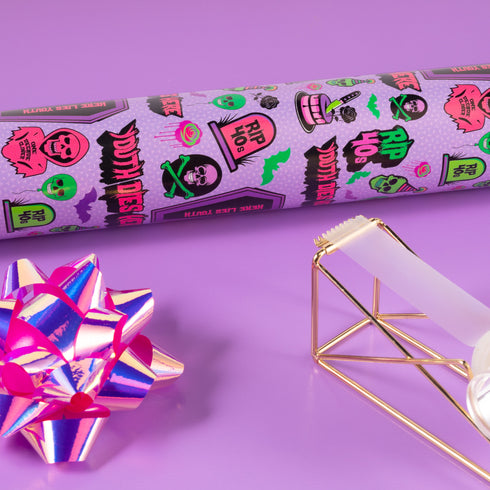 Vibrant purple wrapping paper with gothic-inspired design for 50th birthdays. Features colorful skulls wearing party hats, coffins, 'RIP 40s' tombstones, and 'Youth Dies Here' text. Perfect for edgy, humorous gifts to 50-year-olds.