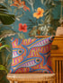 Flat printed square throw pillow cover featuring a faux embroidery texture. The vibrant maximalist design showcases stylized blue, pink, yellow, and white fish swimming in a dynamic, swirling pattern across a bright orange background. The artwork mimics heavy crewelwork yarn and stitching, but the material is a smooth 2D flat print. The pillow is shown as a finished square cover, designed to add bright, colorful eclectic fisherman aesthetic decor to any sofa or seating area.