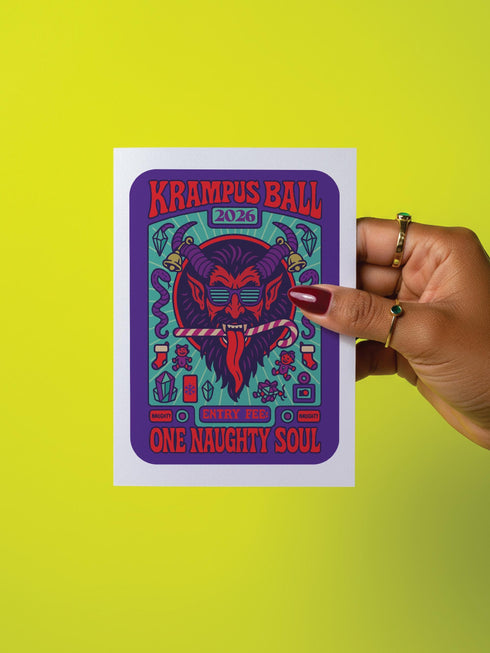A vertical 5x7 inch folded greeting card featuring a detailed, psychedelic illustration of the folklore figure Krampus for a New Year celebration. The card stock has a shimmering pearlescent finish that reflects light, creating a glowing effect on the purple and teal artwork. The design mimics a vintage event poster reading "Krampus Ball 2026" and "Entry Fee: One Naughty Soul" in retro fonts. Krampus is depicted with large horns, sunglasses, and a long tongue holding a candy cane.