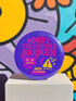 A vibrant purple pinback button with a glossy finish. The main text reads "SORRY, THE SYSTEM'S BROKEN" in a chunky, dripping pink font. Below the text are several retro tech icons in pink and yellow. On the left is a glitching 90s-style computer monitor with a sad face and X's for eyes. In the center is a yellow warning sign with an exclamation point, a lightning bolt, and sparkles. Below is a keyboard command parody that reads "CTRL ALT RESIST.